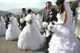 Newlyweds standing in front Gandzasar’s Cathedral of St. John the Baptist, NKR.